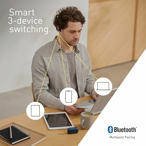 Man using Bluetooth multipoint with laptop, phone, and tablet.