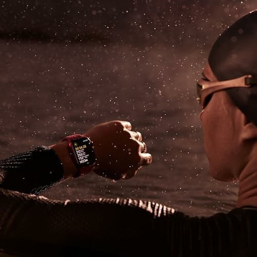 Swimmer in wetsuit checks smartwatch in water