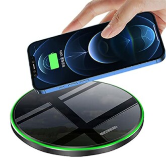 Wireless phone charger with smartphone being charged.