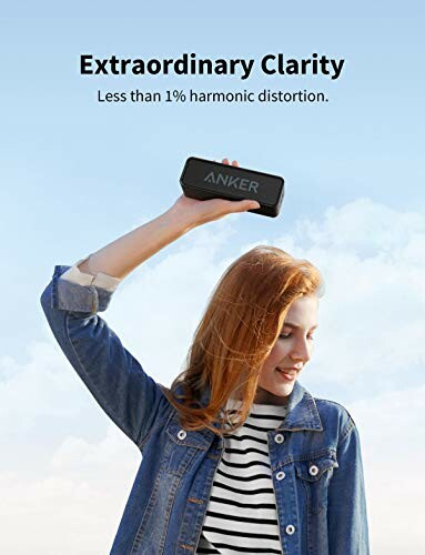 Woman holding Anker speaker outdoors with text about clarity.